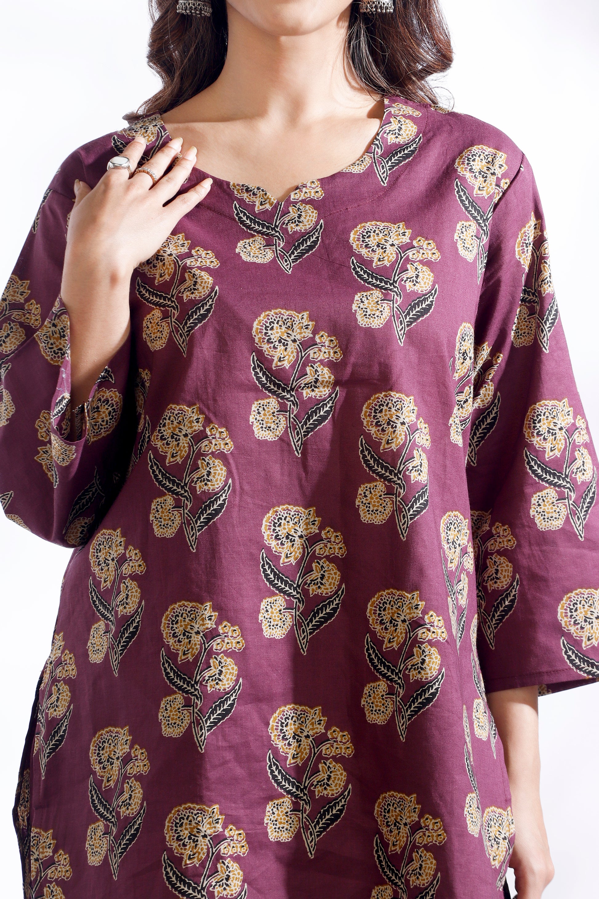 Purple dress with floral pattern worn by a model on a white background