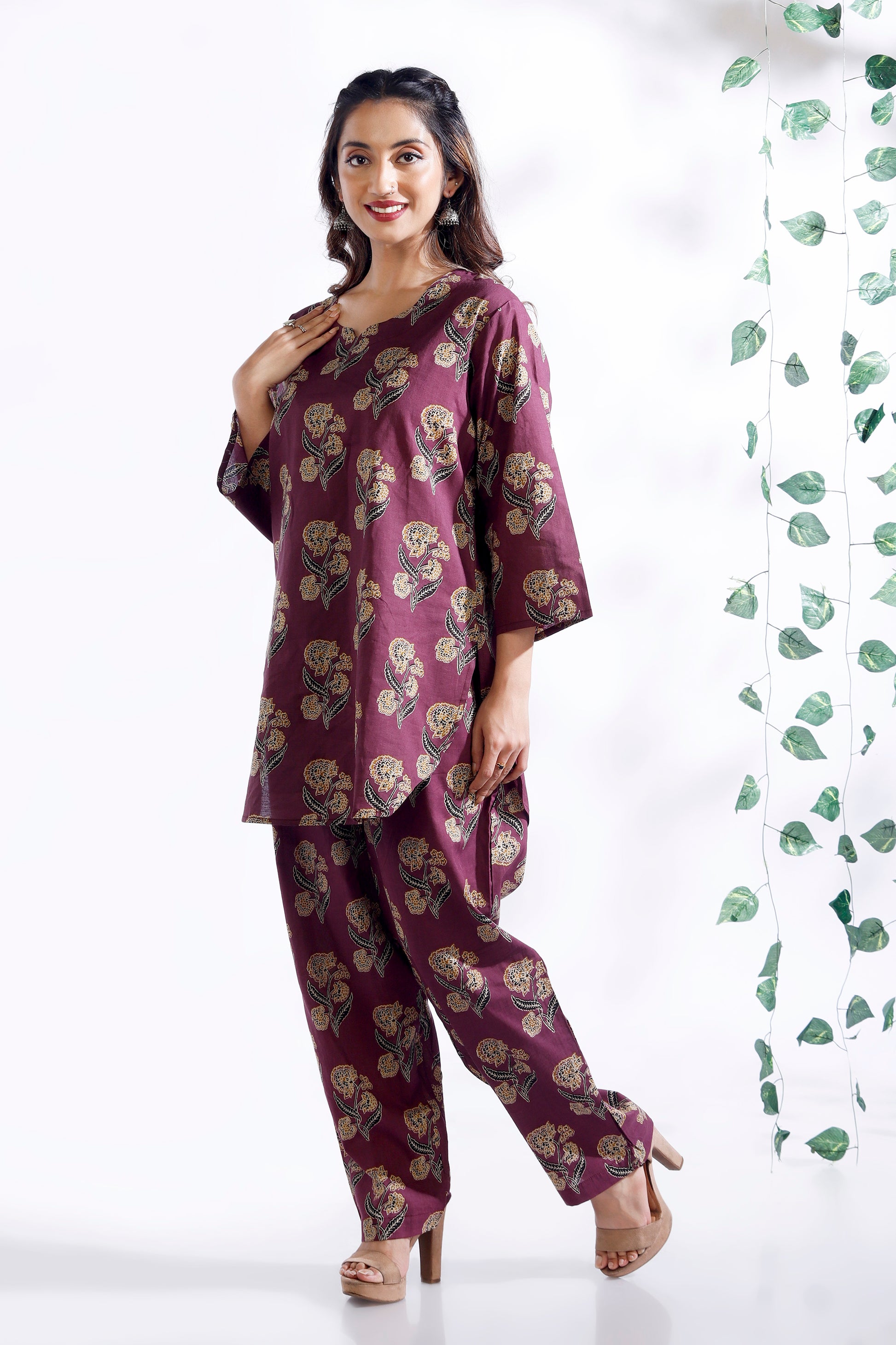 Woman wearing a purple floral outfit with a white background