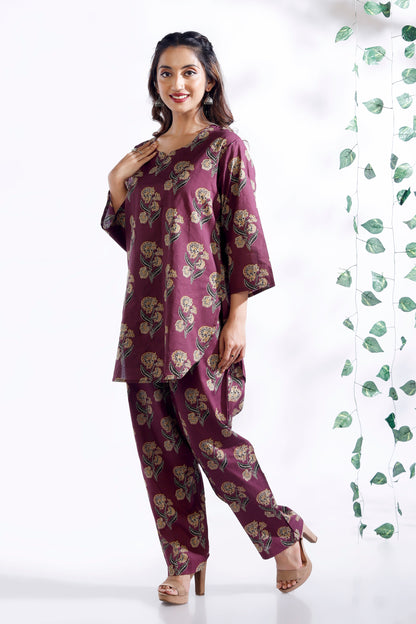 Woman wearing a purple floral outfit with a white background