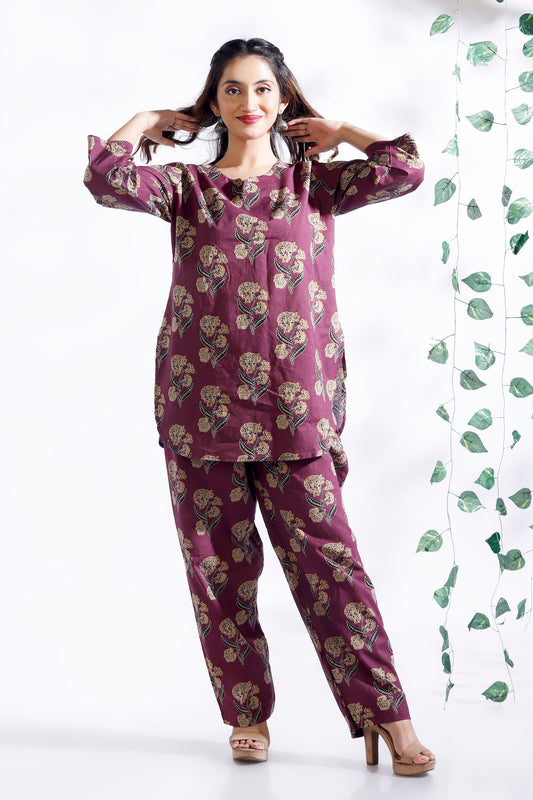 Woman wearing a purple floral pajama set with a white background
