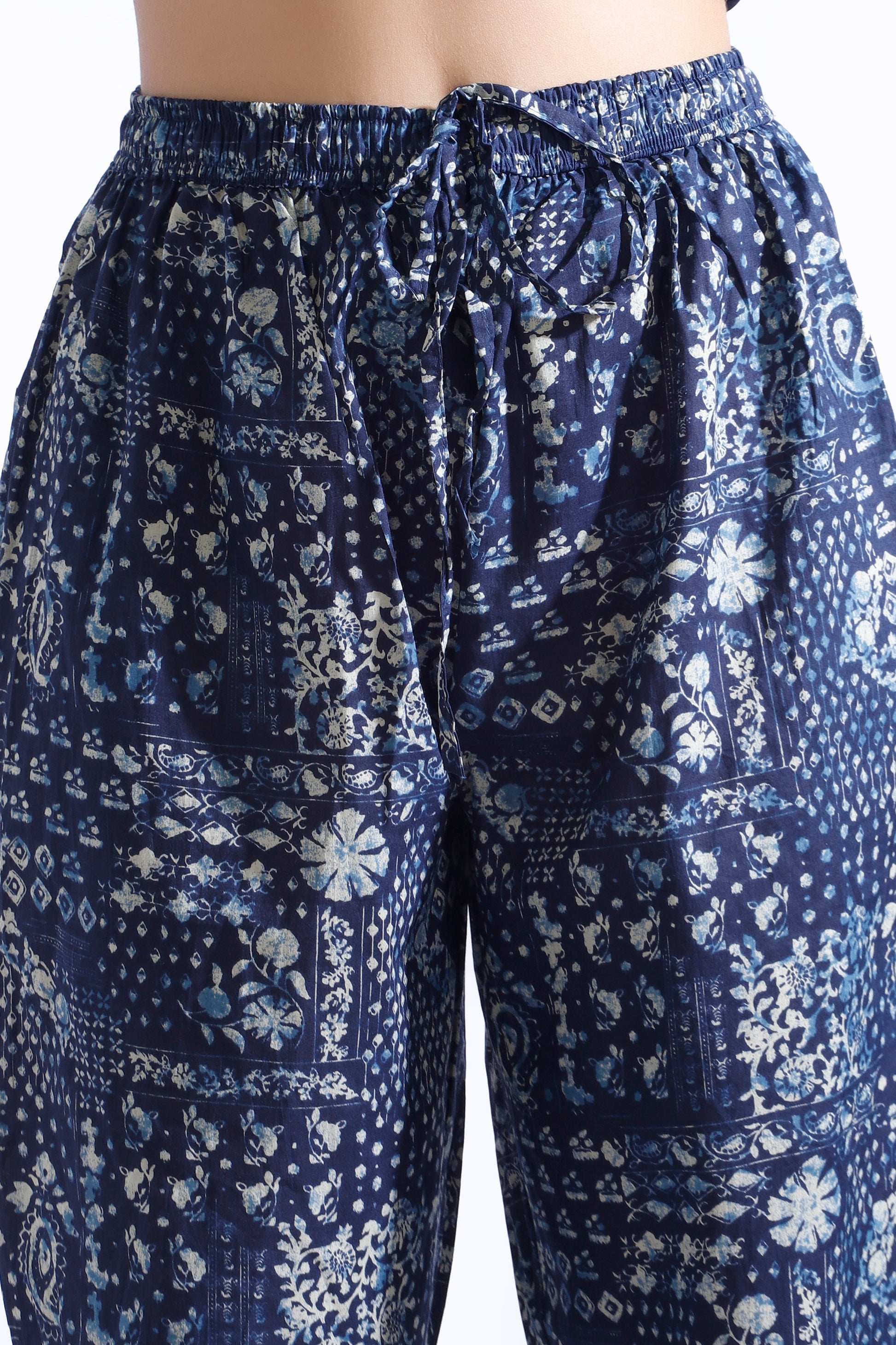 Blue patterned pants with a tie waist on a white background