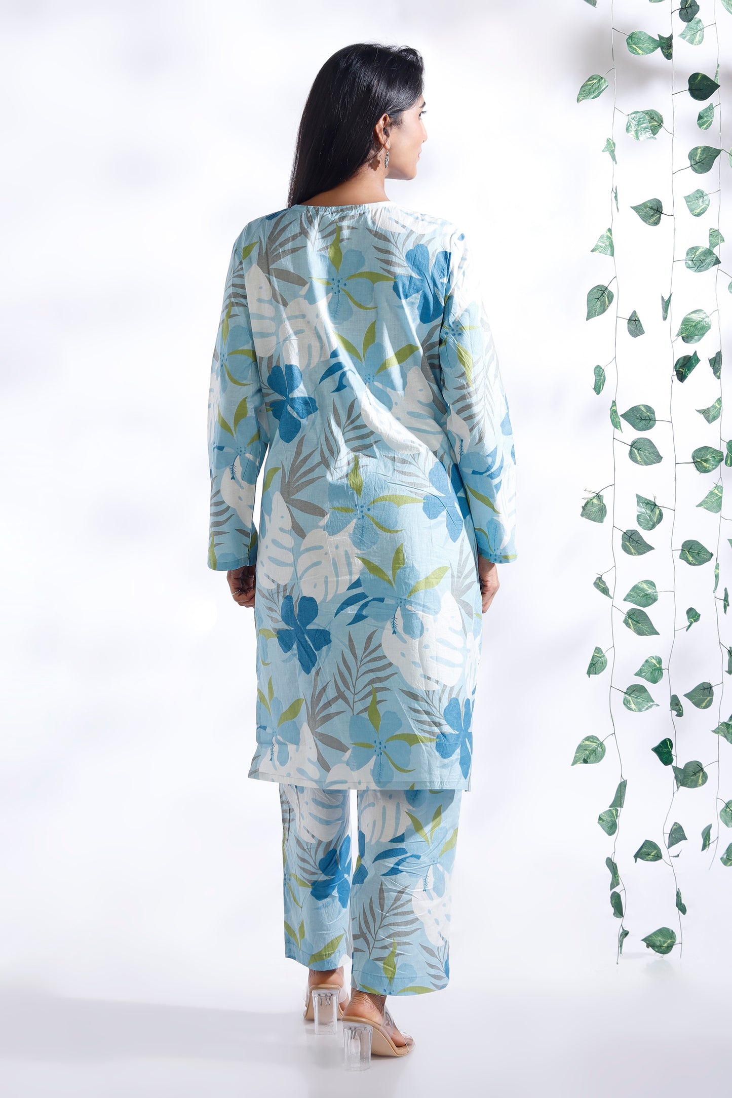 Woman wearing a floral kurta with pants against a white background