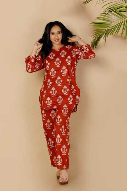 Woman wearing a red patterned outfit against a beige background