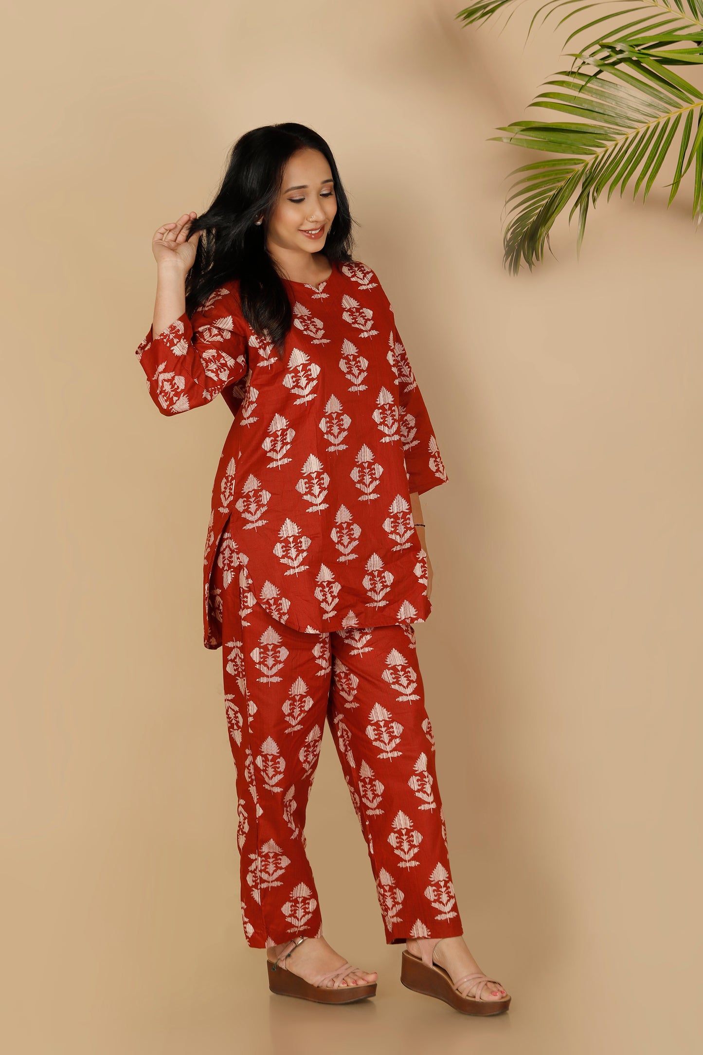 Woman wearing a red and white patterned outfit against a beige background
