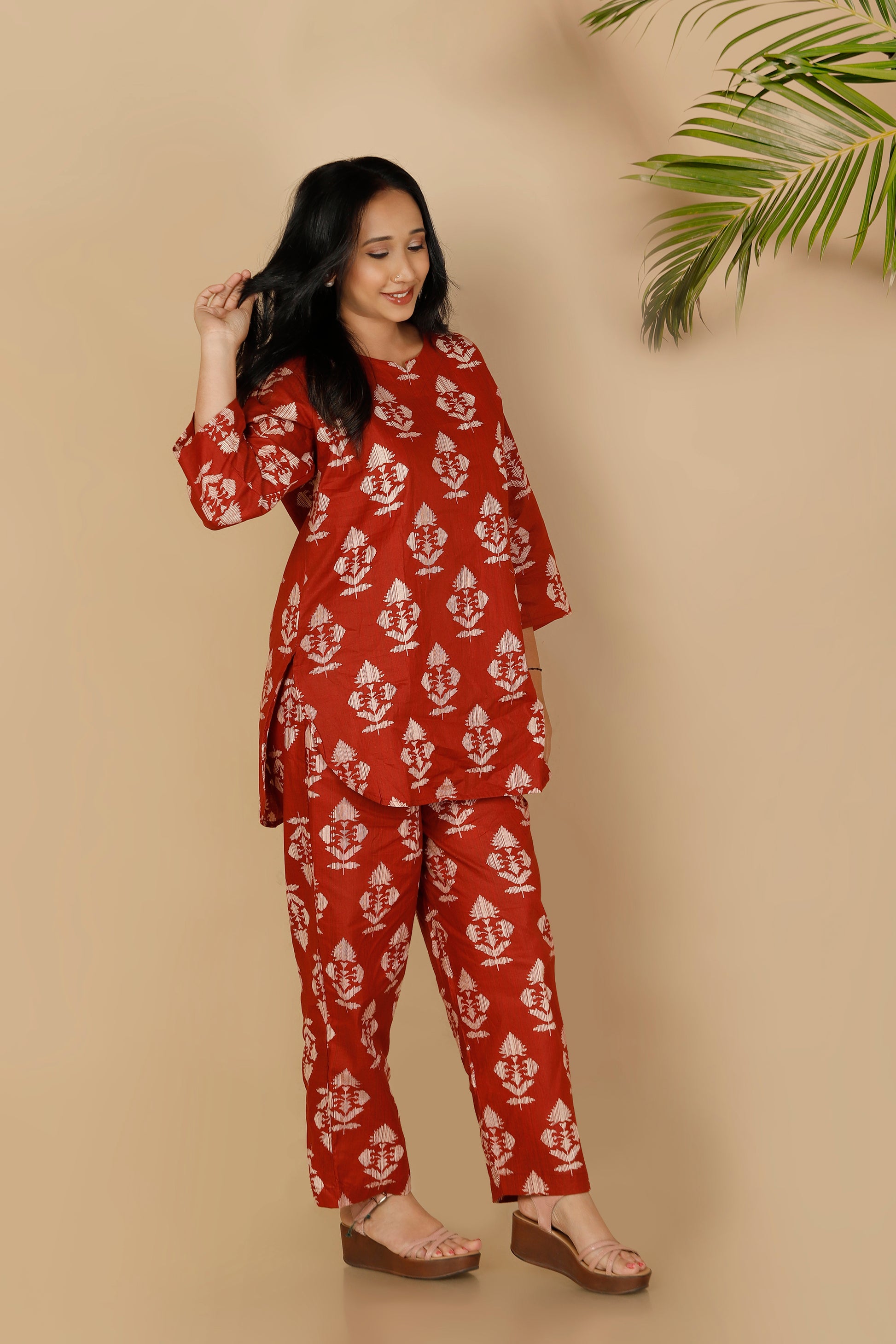 Woman wearing a red and white patterned outfit against a beige background