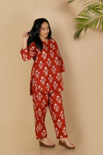 Woman wearing a red and white patterned outfit against a beige background